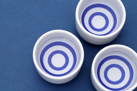 Japanese sake in traditional ceramic ochoko cup on table