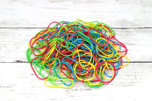 Colorful rubber bands on a white wooden table　