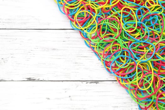 Colorful rubber bands on a white wooden table　