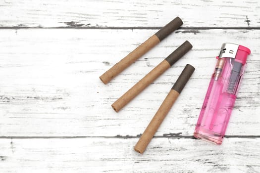 cigarette with lighter on a white grunge wooden table
