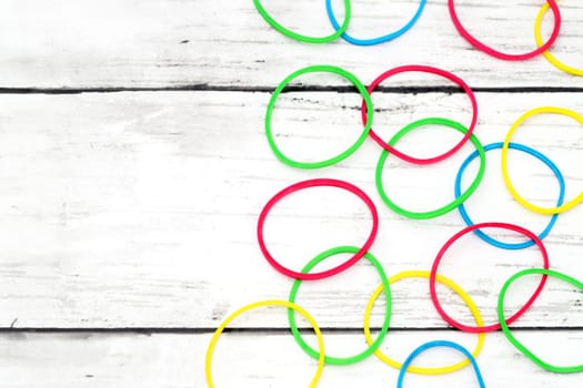 Colorful rubber bands on a white wooden table