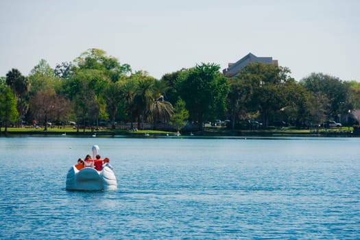 Four people on a pedal boat, Lake Eola Park, Orlando, Florida, USA