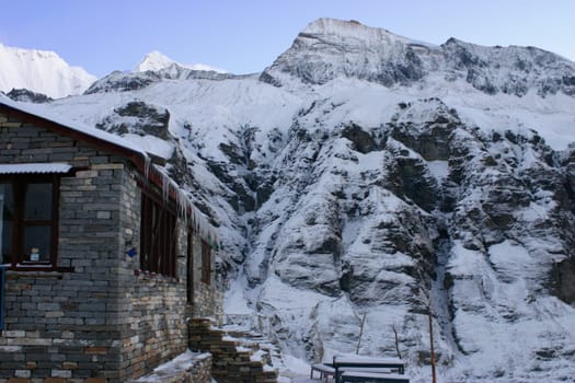 House in front of a snow covered mountain, Annapurna Range, Himalayas, Nepal