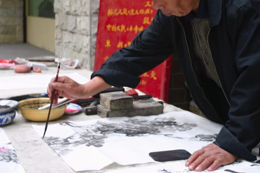 Mid section view of a man calligraphing, Beijing, China