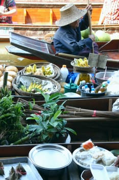 Side profile of a woman rowing boat in the floating market, Thailand