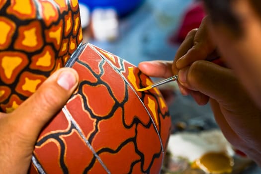 Close_up of a personŽs hand painting on a ceramics, Arrazola, Oaxaca State, Mexico