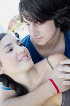 Close_up of a young man embracing a young woman from behind