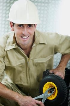 Portrait of a mid adult man tightening a nut of a wheel