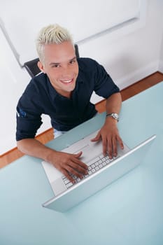 High angle view of a young man using a laptop