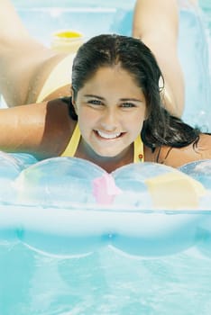 Close_up of a teenage girl lying on a pool raft