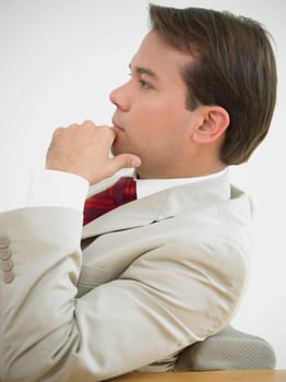 Side profile of a businessman thinking with his hand on his chin