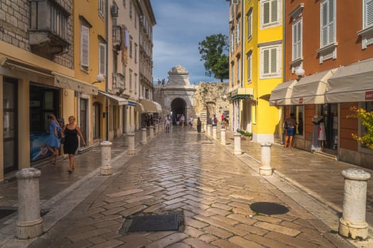 Zadar, Croatia, July 2019 Tourists visiting beautiful narrow streets of the old town district with polished marble cobblestone pavement