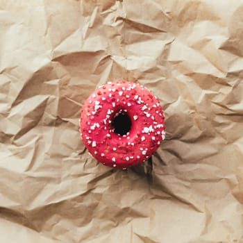 Fresh raspberry donuts on crumpled craft paper. High quality photo