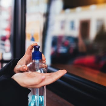 Using of sanitizer before entering the cafe. Blurred background. High quality photo