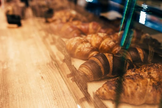 The waiter pulls out croissants in a cafe window. Blurred background. High quality photo