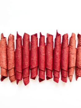 Red fruit leather rolls isolated on white. Fruit candy - pastille. Top view