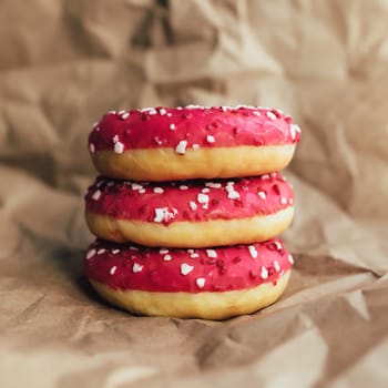 Fresh raspberry donuts on crumpled craft paper. High quality photo
