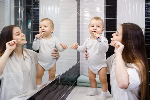 mother and son brush the teeth.