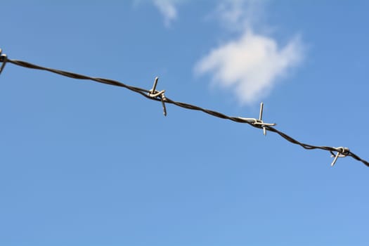 Barbed wire on the fence in front of a private property