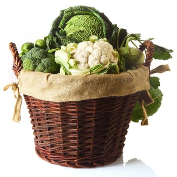 Close up Fresh Farm Vegetables in a Basket, Emphasizing Cauliflower, Brussels Sprouts, Broccoli and Cabbage. Isolated on White Background.