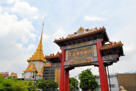 Chinatown gate with Wat Traimit, temple of golden Buddha in Yaowarat, Chinatown, Bangkok, Thailand