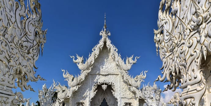 Beautiful ornate white temple located in Chiang Rai northern Thailand. Wat Rong Khun - White Temple, is a contemporary unconventional Buddhist temple.