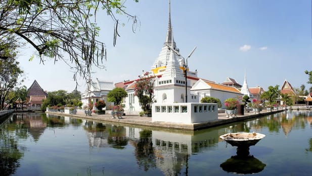 Thai Buddhist temple Wat Khan Lad is surrounded by a pond of water in Bangkok, Thailand