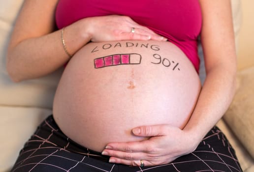 Pregnant woman with loading concept painted on her belly