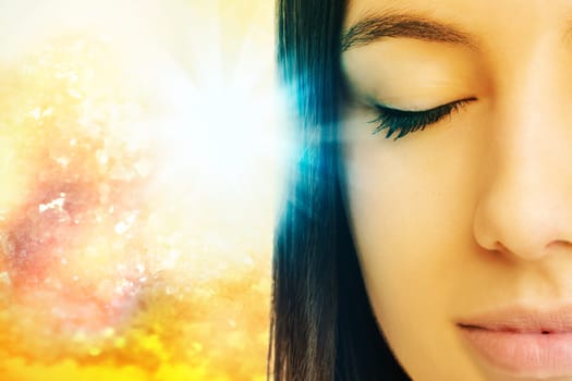 Macro close up of young woman meditating with eyes closed.Conceptual spiritual background with light beam.