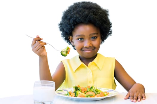 Close up portrait of cute african girl with afro hairstyle eating healthy vegetable dish. Isolated on white.