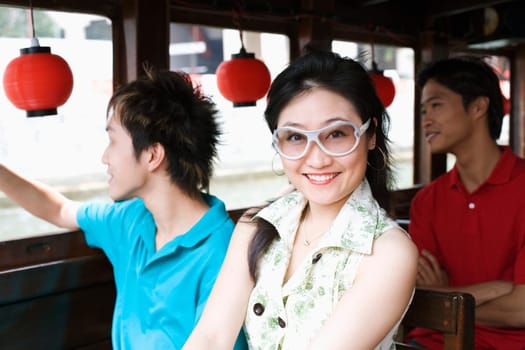 Portrait of a young woman with two young men traveling in a tourboat