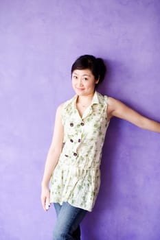 Portrait of a young woman leaning against a wall