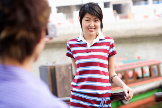 Rear view of a young man taking a picture of a young woman