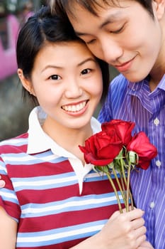 Close-up of a young couple holding a bunch of roses