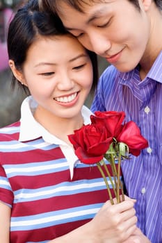 Close-up of a young couple holding a bunch of roses