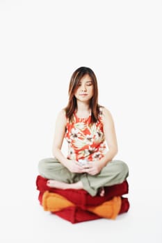 Mid adult woman sitting on cushions with her eyes closed