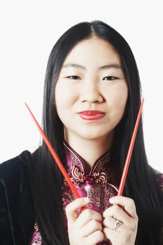 Portrait of a young woman holding chopsticks