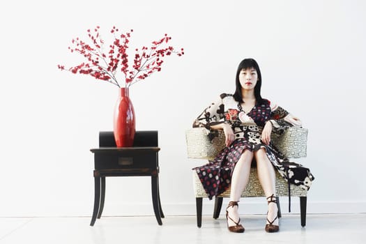 Portrait of a young woman sitting on an armchair
