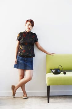 Portrait of a young woman leaning on a couch