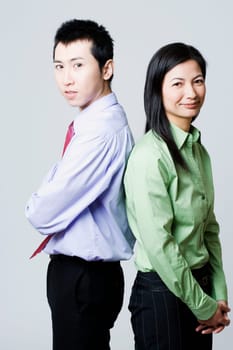 Side profile of a businessman and a businesswoman standing back to back