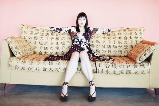 Portrait of a young woman sitting on a couch