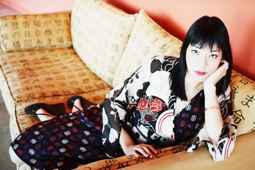 Portrait of a young woman leaning on a couch
