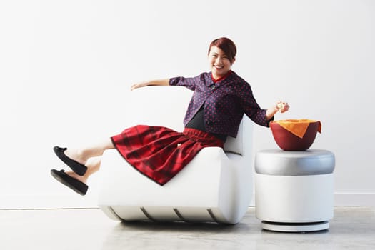 Portrait of a young woman sitting on a couch smiling