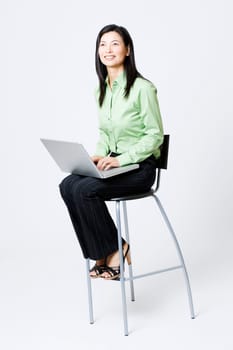 Businesswoman sitting on a chair and using a laptop