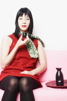 Portrait of a young woman sitting on a couch holding a cup