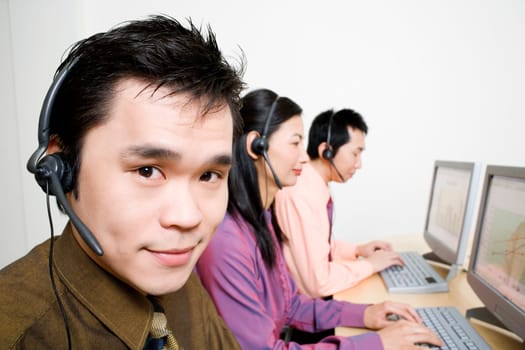 Three customer service representatives working on computers
