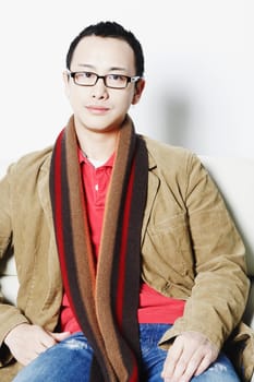 Portrait of a young man sitting on an armchair