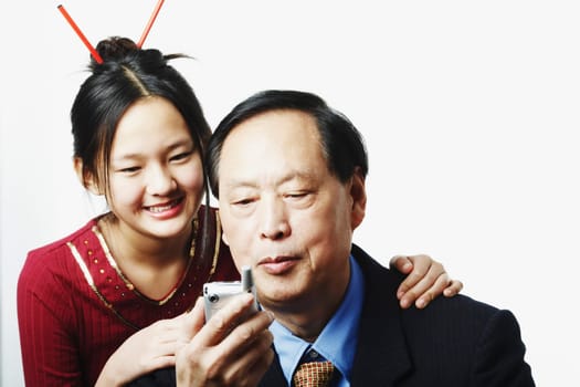 Close-up of a granddaughter standing behind her grandfather