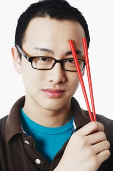 Portrait of a young man holding chopsticks
