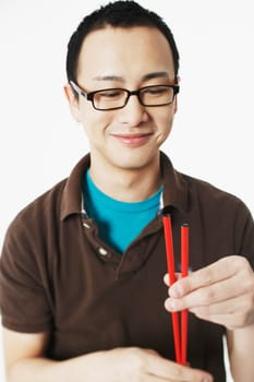 Portrait of a young man holding chopsticks